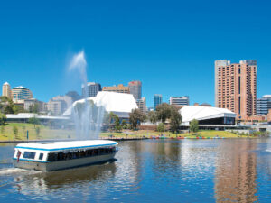 Popeye boat cruising along the River Torrens with Adelaide’s cityscape in the background