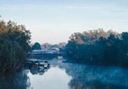 Early morning mist over the Murray River at Echuca with historic paddle steamers docked by the wharf